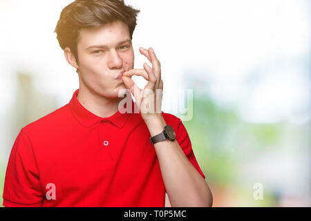 Young handsome man wearing red t-shirt over isolated background mouth and lips shut as zip with fingers. Secret and silent, taboo talking Stock Photo