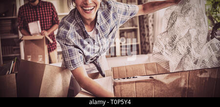 Happy couple unpacking cartons together Stock Photo