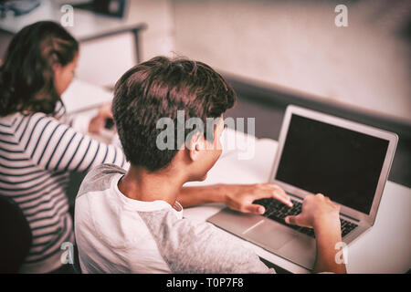 Student using laptop in classroom Stock Photo