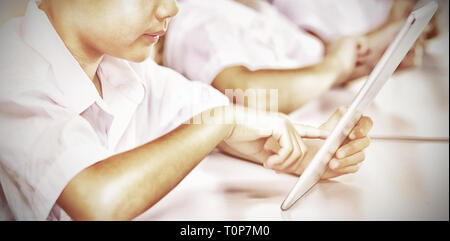 Kids using digital tablet in classroom Stock Photo