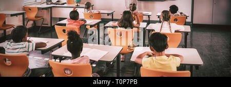 Teacher giving lesson to her students Stock Photo