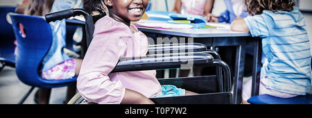 Disabled schoolgirl smiling in classroom Stock Photo