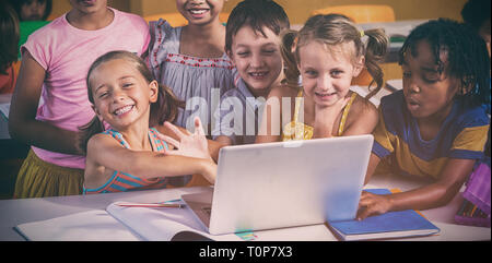 Smiling multi ethnic children using laptop Stock Photo