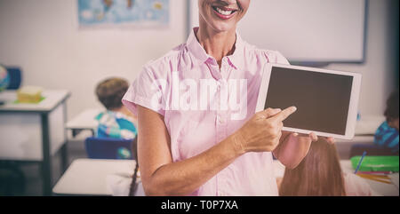 Female teacher pointing over digital tablet Stock Photo