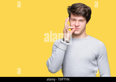 Young handsome man wearing winter sweater over isolated background mouth and lips shut as zip with fingers. Secret and silent, taboo talking Stock Photo