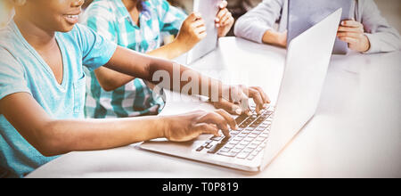 Kids using laptop and digital tablet in library Stock Photo