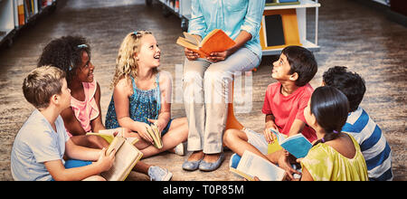Teacher with students reading books Stock Photo