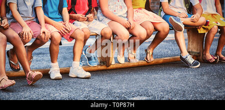 Smiling schoolchildren on seat Stock Photo