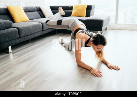 Adult Woman Training Legs and Back Doing Plank Donkey Kicks Stock Photo
