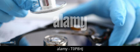 male repairman wearing blue gloves holding stethoscope on hard Stock Photo