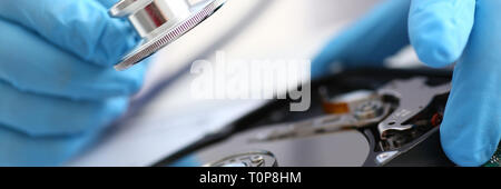 male repairman wearing blue gloves holding stethoscope on hard Stock Photo