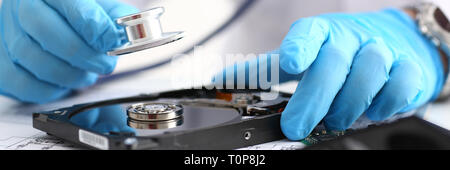 male repairman wearing blue gloves holding stethoscope on hard Stock Photo