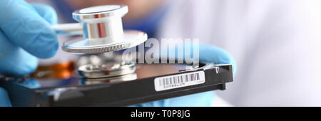 male repairman wearing blue gloves holding stethoscope on hard Stock Photo