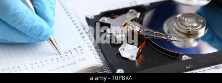 male repairman wearing blue gloves holding stethoscope on hard Stock Photo