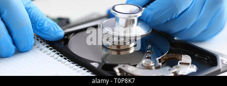 male repairman wearing blue gloves holding stethoscope on hard Stock Photo