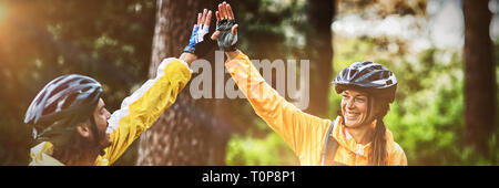 Biker couple giving high five to each other in countryside Stock Photo