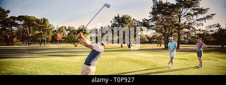 Friends playing golf on field Stock Photo