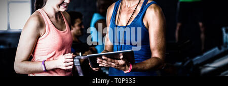 Smiling friends with digital tablet in gym Stock Photo