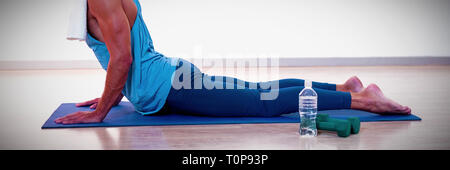 Man doing cobra pose on exercise mat Stock Photo