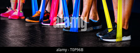 Athletes exercising with resistance band in gym Stock Photo