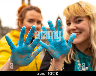 Glasgow, Scotland, UK. 21 March, 2019. A  'Blue Wave' demonstration by the Extinction Rebellion climate change protest group saw protesters make blue footprints, made from water-soluble paint, across George Square to the City Chambers. The peaceful protest briefly held up traffic. The Group aims to highlight threat of rising water levels in the River Clyde and of global climate change. L to R activists Emrys and Cheyenne after the Blue Wave protest. Credit: Iain Masterton/Alamy Live News Stock Photo