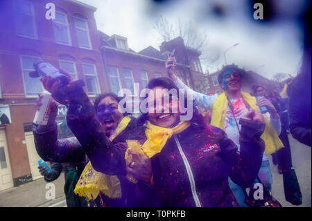 A woman is seen throwing coloured powder at the camera during the celebration. Millions of people around the world celebrate the annual Holi Hangámá Festival, also known as the Festival of Colours. For Hindus it's a celebration of the arrival of spring, the New Year and victory all in one. The largest Indian population in Europe (outside of the UK) are found in The Hague, this is one of the largest in Europe. The highlight of the Holi celebrations is the procession through the multicultural Transvaal and Schilderswijk neighborhoods. Participants in the procession throw brightly colored powder  Stock Photo