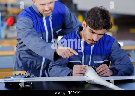 two engineers working in a large aircraft hangar Stock Photo