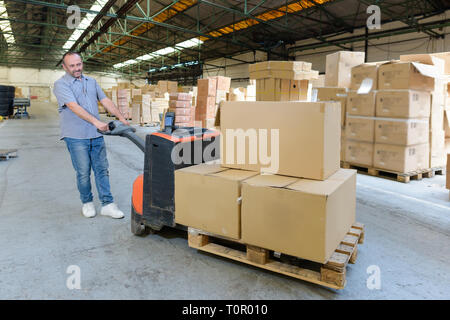 porter carrying boxes in a warehouse Stock Photo