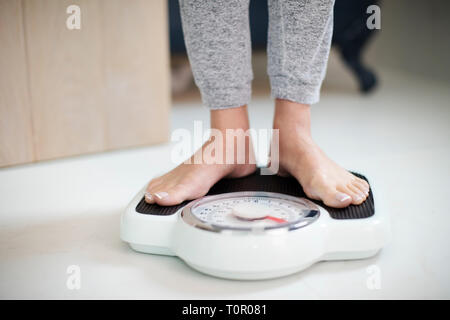 Close Up Of Woman Standing On Bathroom Scales At Home Stock Photo