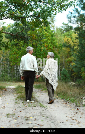 Portrait of senior couple walking in autumn forest Stock Photo