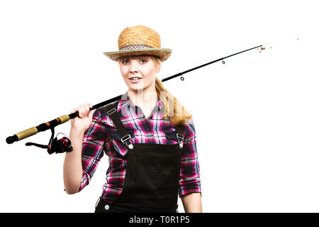 Spinning, angling, cheerful fisherwoman concept. Happy woman in sun hat holding fishing rod, having fun and smiling. Stock Photo
