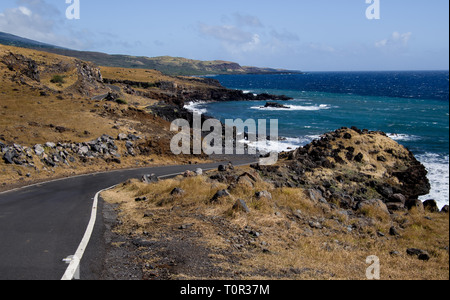 Maui South Coast Highway:  A narrow road curves through arid terrain along a volcanic shoreline as the Piilani Highway approaches the east end of Maui Stock Photo