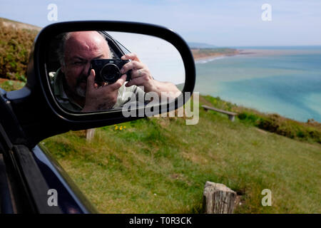 photographer,taking,picture,of,Compton Bay,reflected,in,car,side,mirror,Isle of Wight,England,UK, Stock Photo
