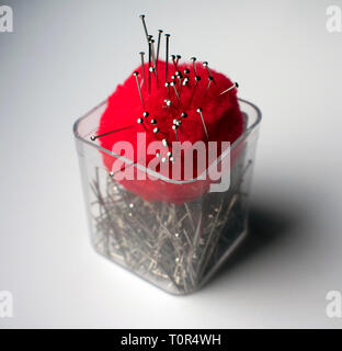 Sewing pins and pincushion in plastic cup Stock Photo