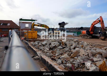 view,over,fence,of,demolition,site,building,diggers,factory,warehouse,concrete,debris,bricks,roof,East Cowes, Isle of Wight,England,UK, Stock Photo