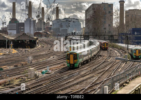 Southern Rail train approaching Ebury Bridge on the final approach to Victoria Station ,with Battersea Power Station in the distance ,London, UK Stock Photo