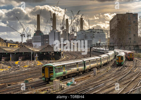 Southern Rail train approaching Ebury Bridge on the final approach to Victoria Station ,with Battersea Power Station in the distance, London, UK
