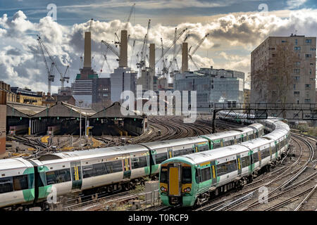 Southern Rail train approaching Ebury Bridge on the final approach to Victoria Station,with Battersea Power Station in the distance ,London, UK Stock Photo