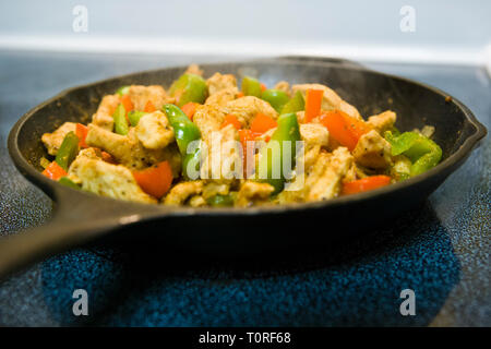 Chicken Fajitas cooking in a iron skillet on a stove top. Stock Photo