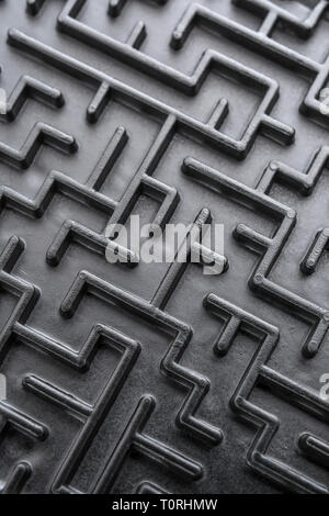 Macro shot of small toy maze painted black. For complex, getting lost, navigating, problem solving, unreachable goals, Brexit negotiations talks. Stock Photo