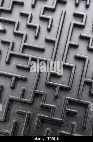 Macro shot of small toy maze painted black. For complex, getting lost, navigating, problem solving, unreachable goals, Brexit negotiations talks. Stock Photo