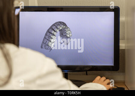 Woman working on computer with dental software platform Stock Photo