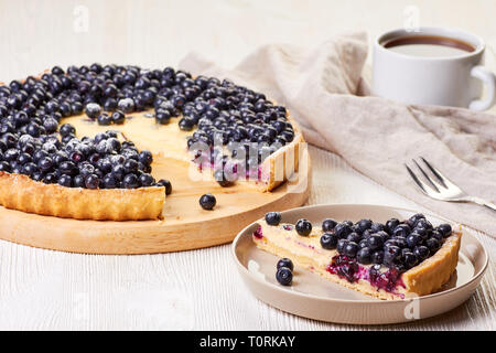 Homemade custard tart with blueberries on white wooden table Stock Photo