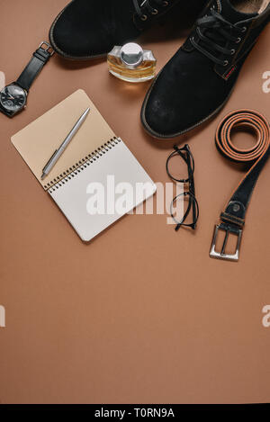Fathers Day mockup with pen, perfume, belt, footwear, notepad and eyeglasses on brown background. Set of stylish male clothes and accessories. Flat la Stock Photo