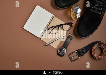 Fathers Day mockup with pen, perfume, belt, footwear, notepad and eyeglasses on brown background. Set of stylish male clothes and accessories. Flat la Stock Photo
