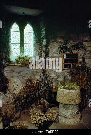 View SW of ancient font in St Beuno's church, Pistyll, Lleyn Peninsula, North Wales, UK, with an unusual ring-chain design symbolizing eternal life. Stock Photo