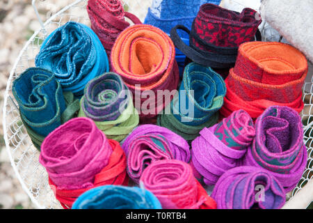 Many colorful plaids made of felt rolled up in a basket Stock Photo