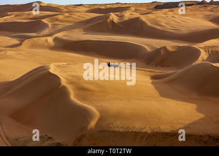 A truck driving in Kubuqi desert, in the Ordor highland of Inner Mongolia, China. Stock Photo