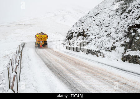 Snow plough clearing the road and spreading salt along the Dalveen Pass in the Lowther Hills, Dumfries and Galloway, Scottish borders, Scotland Stock Photo