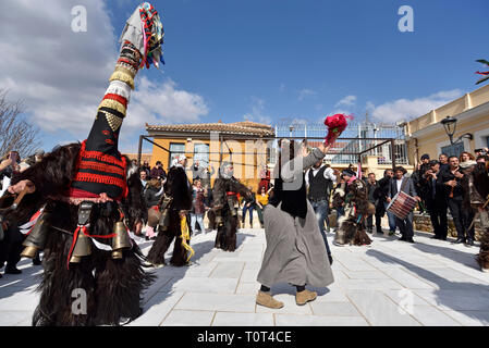 Men from Northern Greece wearing traditional costumes with bells, dance during carnival festival in Athens, Greece Stock Photo